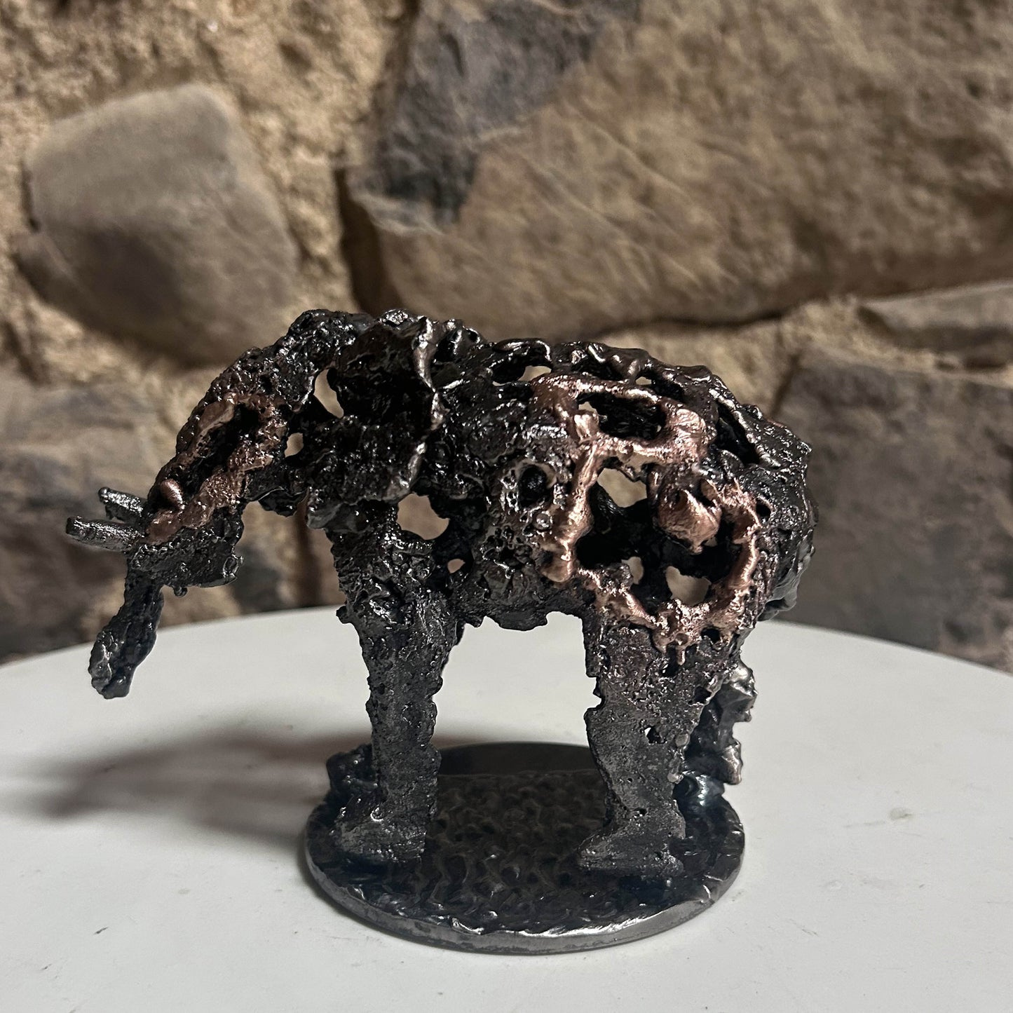 Sculpture en dentelle de métal représentant un éléphant, mélange d'acier gris et de bronze doré, réalisée par l'artiste Philippe Buil.