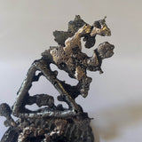 Sculpture représentant le symbole du feu réalisée en dentelle de métal. 
Une métaphore de la transformation, de la passion et de l'énergie créatrice.