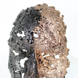 Cette sculpture représente un visage humain, créé avec une technique de dentelle de métal unique.