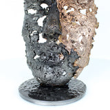 Cette sculpture représente un visage humain, créé avec une technique de dentelle de métal unique.