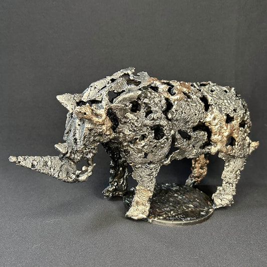 Sculpture contemporaine d'un rhinocéros en dentelle de métal acier et bronze par l'artiste sculpteur Philippe Buil vue de profil