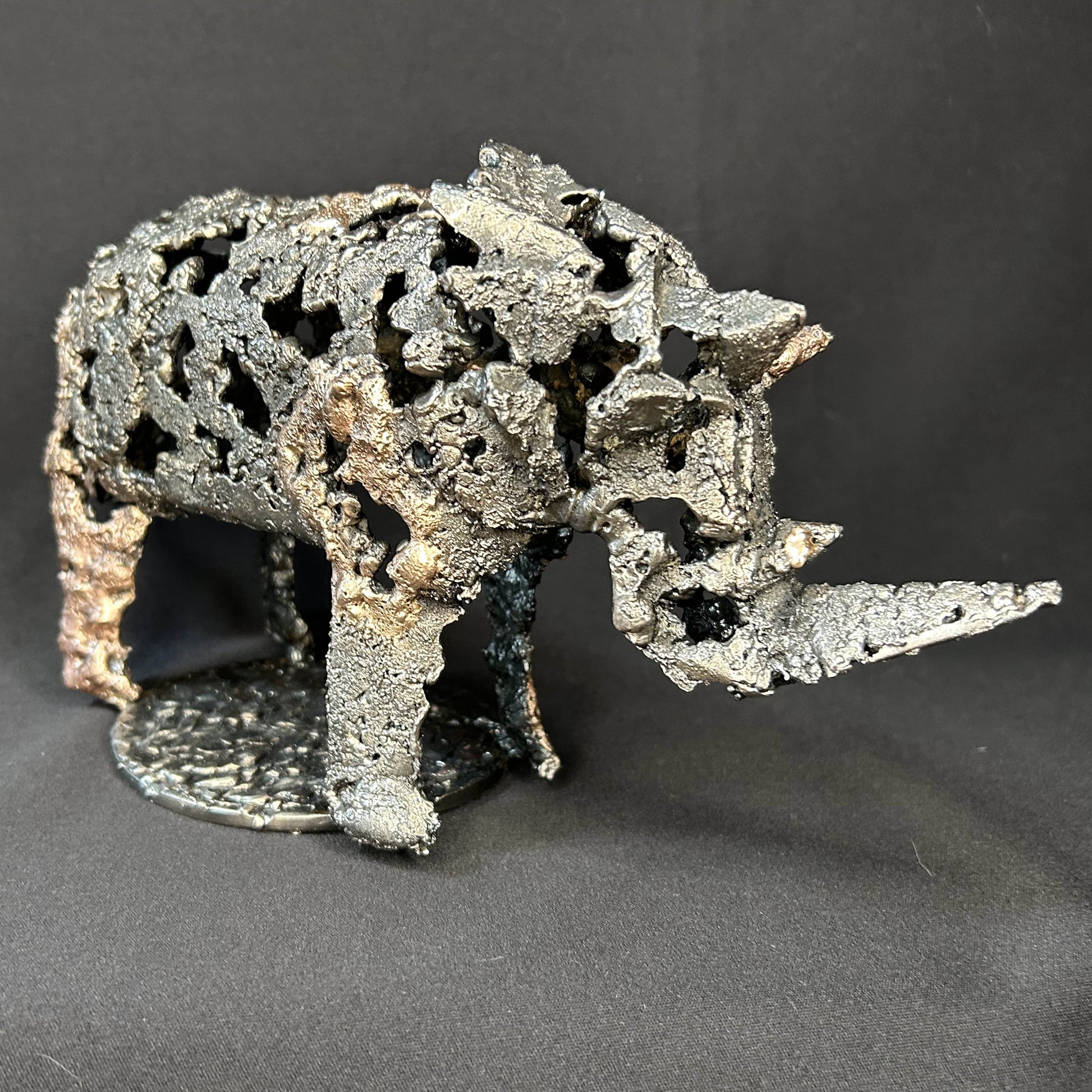 Sculpture contemporaine d'un rhinocéros en dentelle de métal acier et bronze par l'artiste sculpteur Philippe Buil vue de profil
