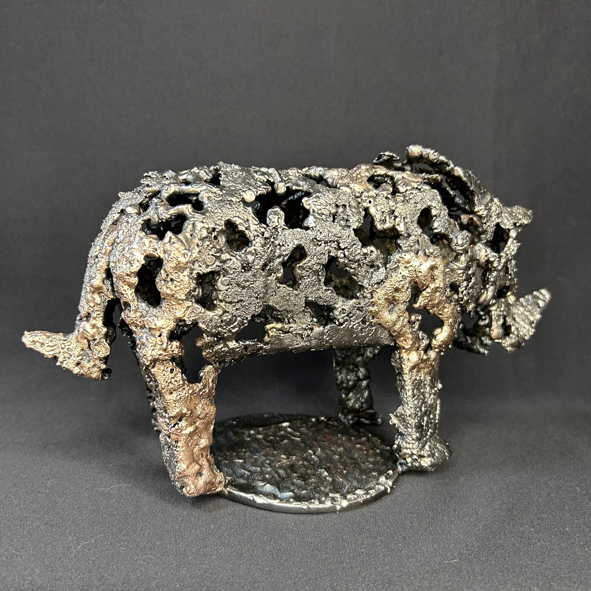Sculpture contemporaine d'un rhinocéros en dentelle de métal acier et bronze par l'artiste sculpteur Philippe Buil vue de côté
