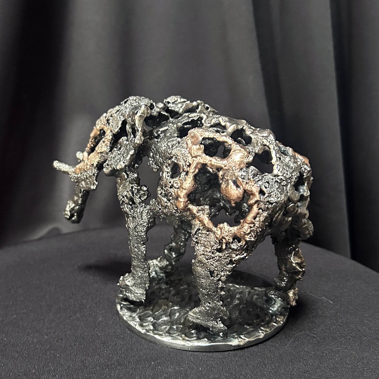 Sculpture en dentelle de métal représentant un éléphant, mélange d'acier gris et de bronze doré, réalisée par l'artiste Philippe Buil.