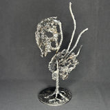 Sculpture en dentelle de métal représentant une tête de mort associée à une coquille Saint-Jacques, réalisée en acier et bronze par Philippe Buil.