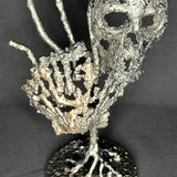 Sculpture en dentelle de métal représentant une tête de mort associée à une coquille Saint-Jacques, réalisée en acier et bronze par Philippe Buil.