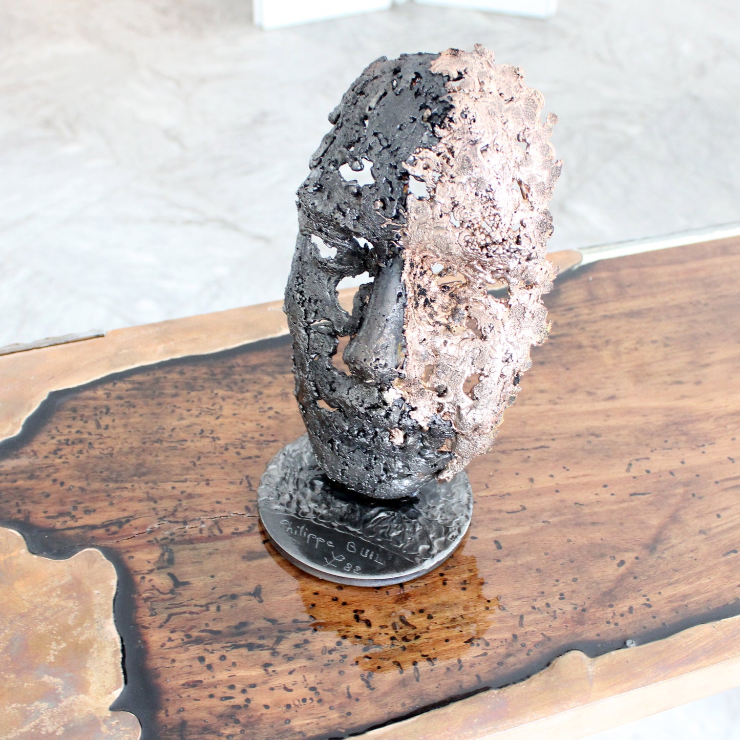 Cette sculpture représente un visage humain, créé avec une technique de dentelle de métal unique.