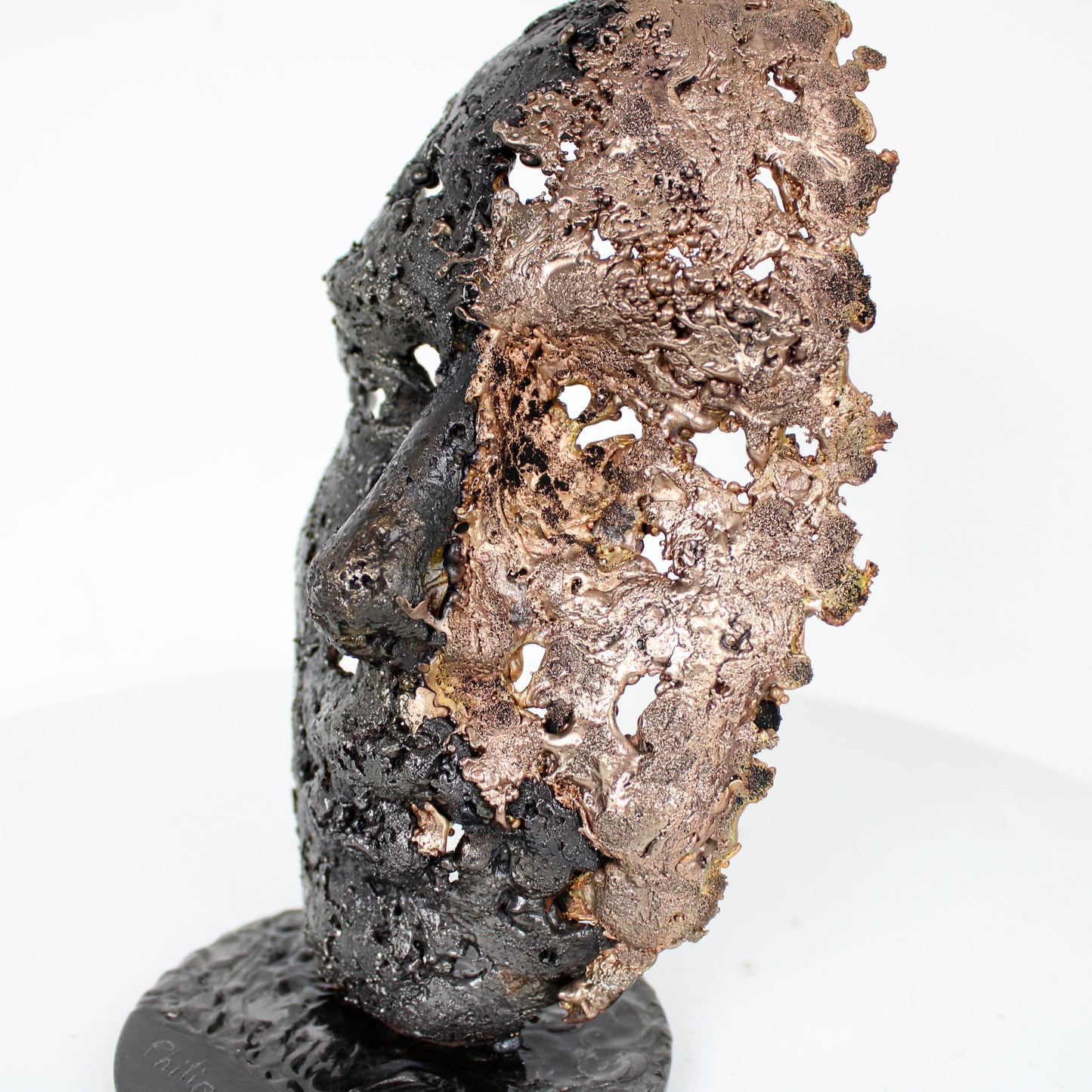 Cette sculpture représente un visage humain, créé avec une technique de dentelle de métal unique.