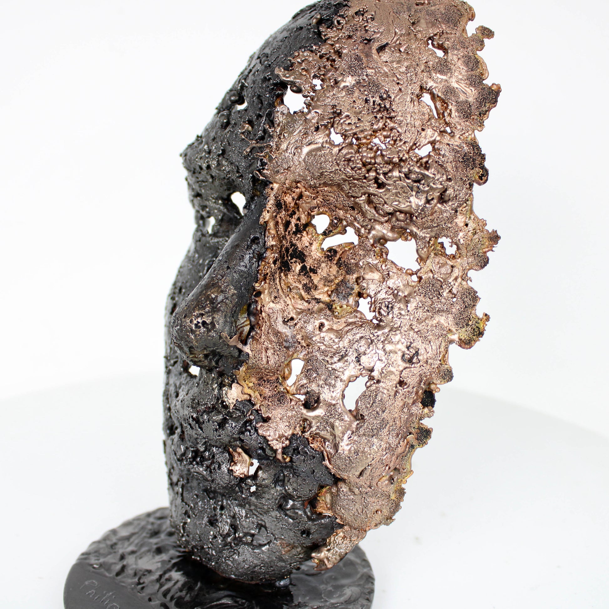 Cette sculpture représente un visage humain, créé avec une technique de dentelle de métal unique.