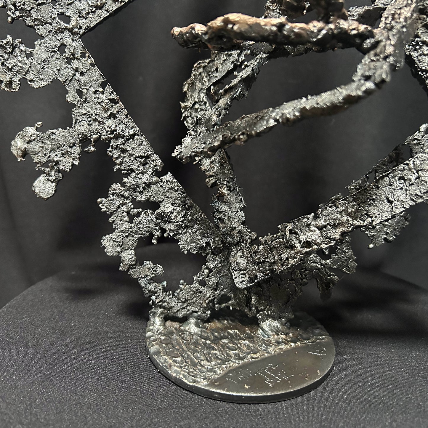 Détail sculpture métal abstraite sur socle rond