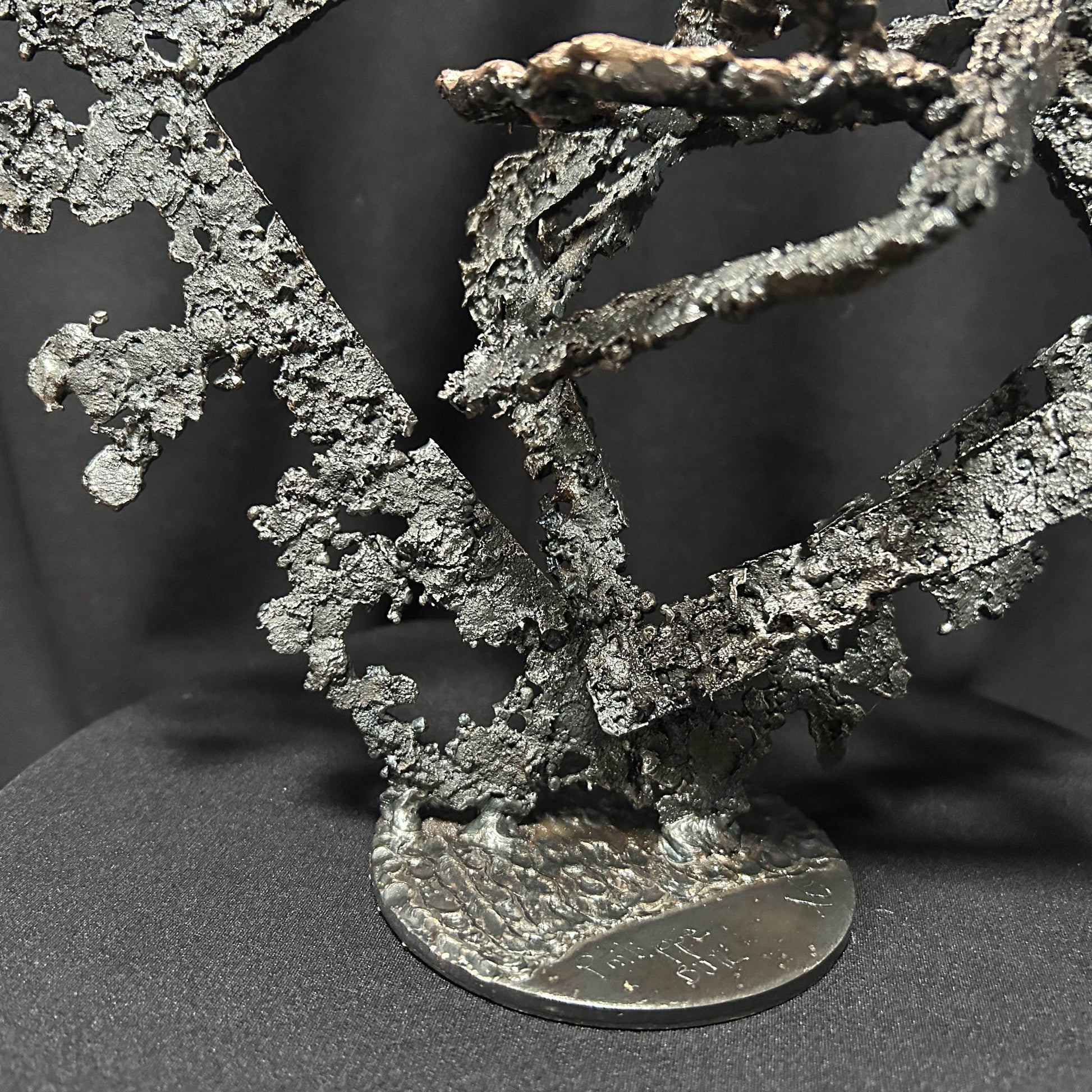 Détail sculpture métal abstraite sur socle rond