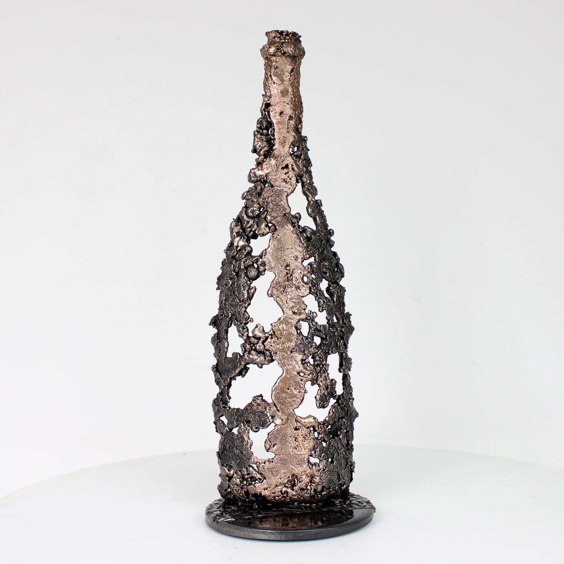 Sculpture de Philippe Buil représentant une bouteille de champagne en dentelle de métal : acier et bronze