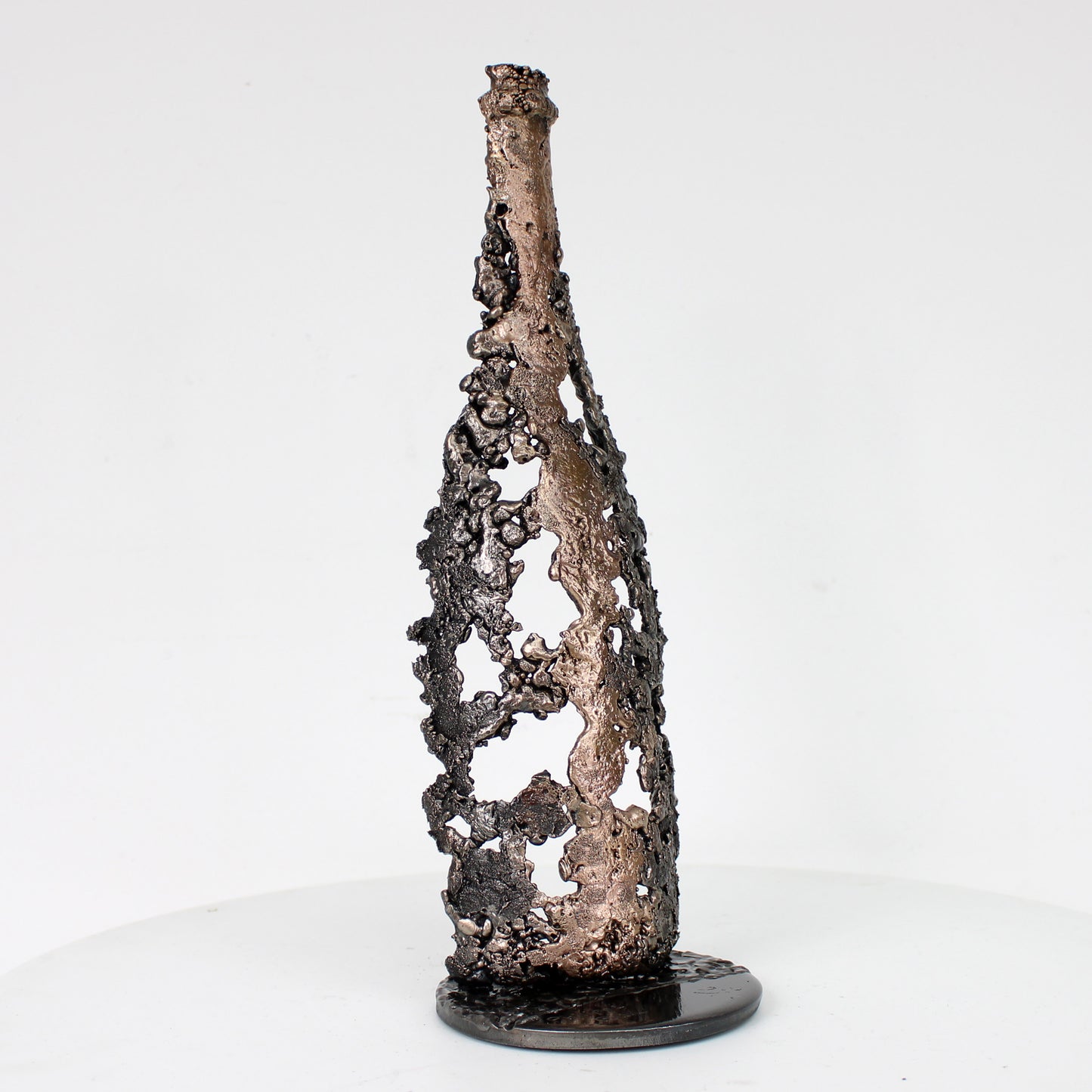 Sculpture de Philippe Buil représentant une bouteille de champagne en dentelle de métal : acier et bronze