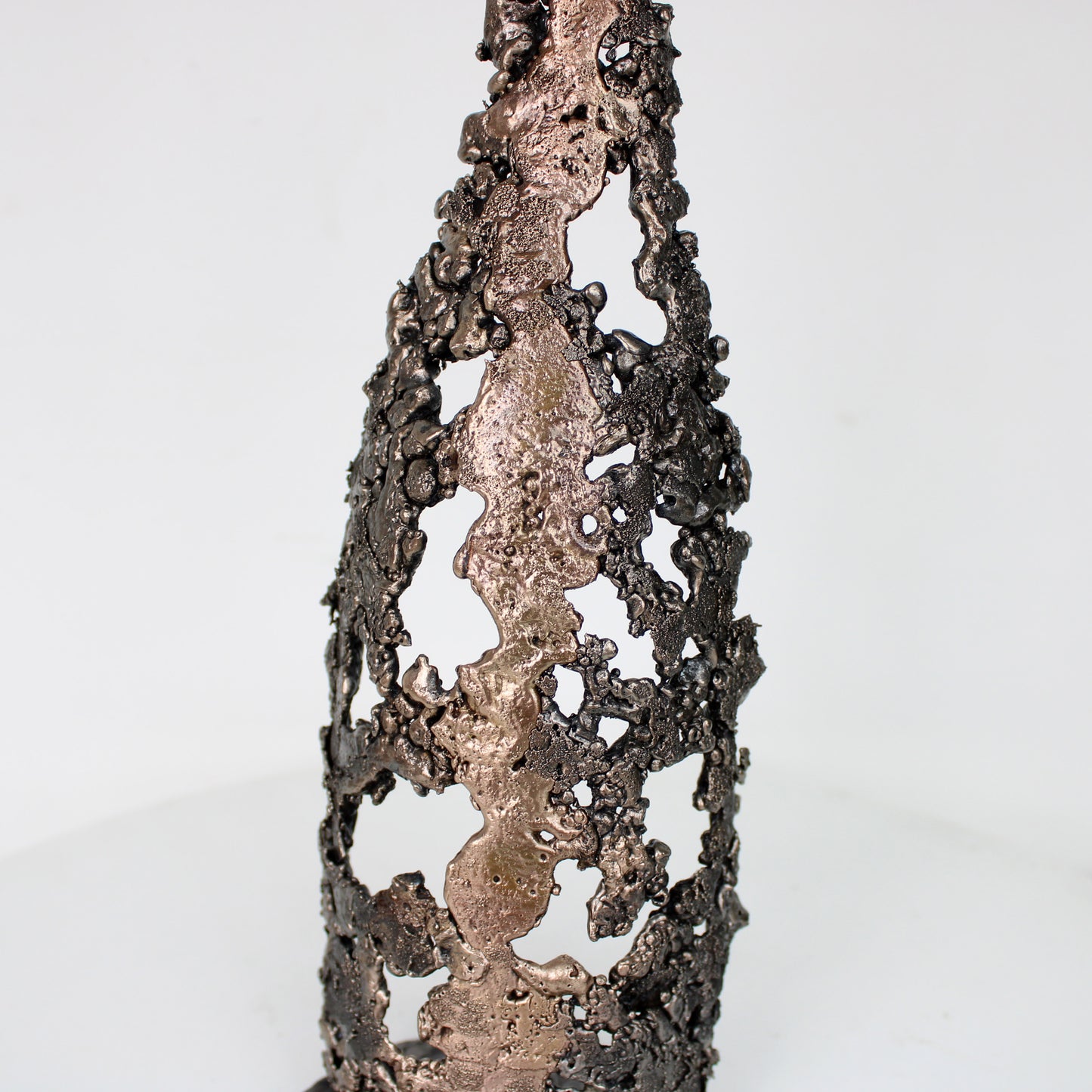 Sculpture de Philippe Buil représentant une bouteille de champagne en dentelle de métal : acier et bronze