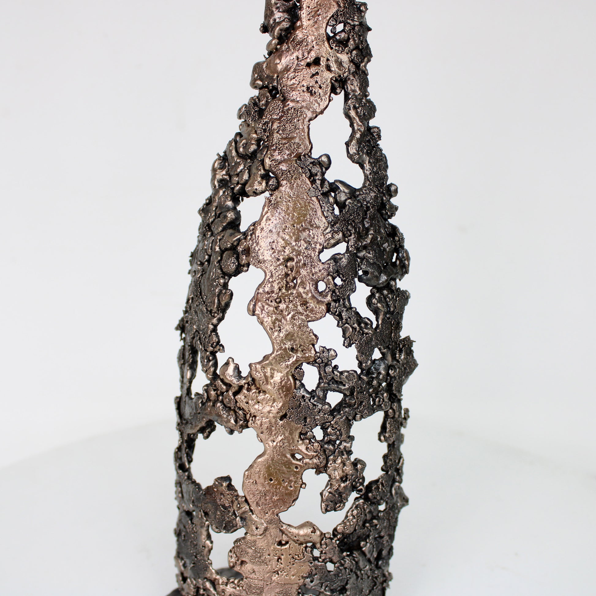 Sculpture de Philippe Buil représentant une bouteille de champagne en dentelle de métal : acier et bronze