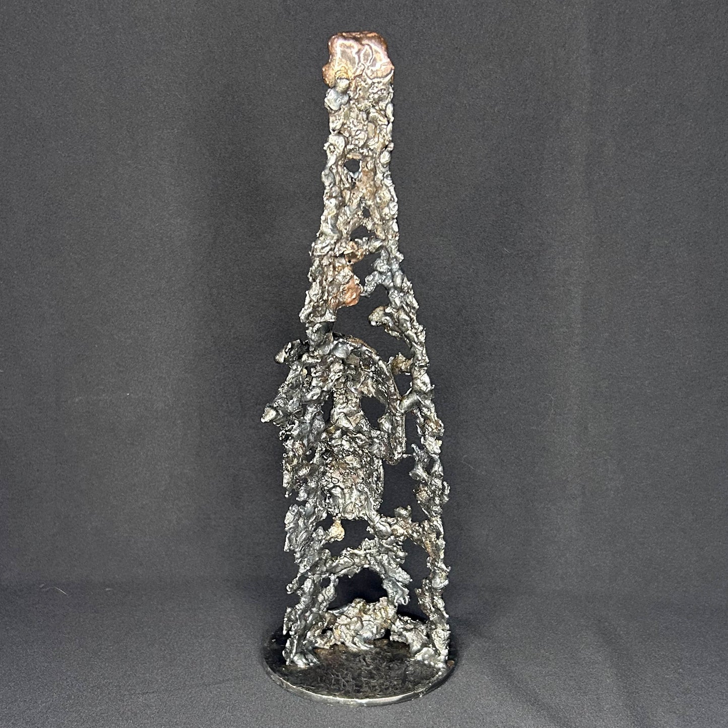 Sculpture en dentelle de métal représentant une tête de mort intégrée à une bouteille de vin, réalisée en acier et bronze par Philippe Buil.