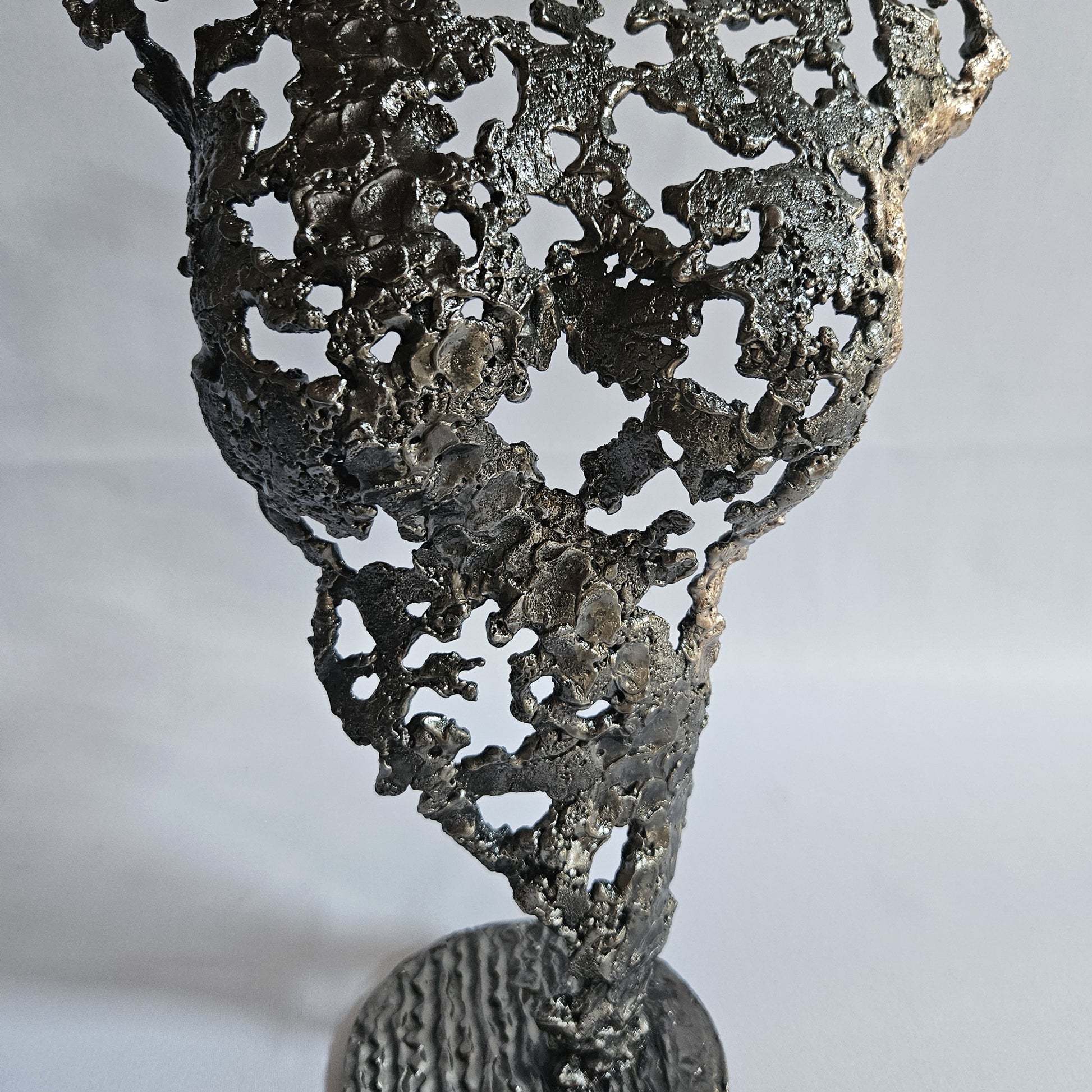Détail corps féminin en acier et bronze effet dentelle