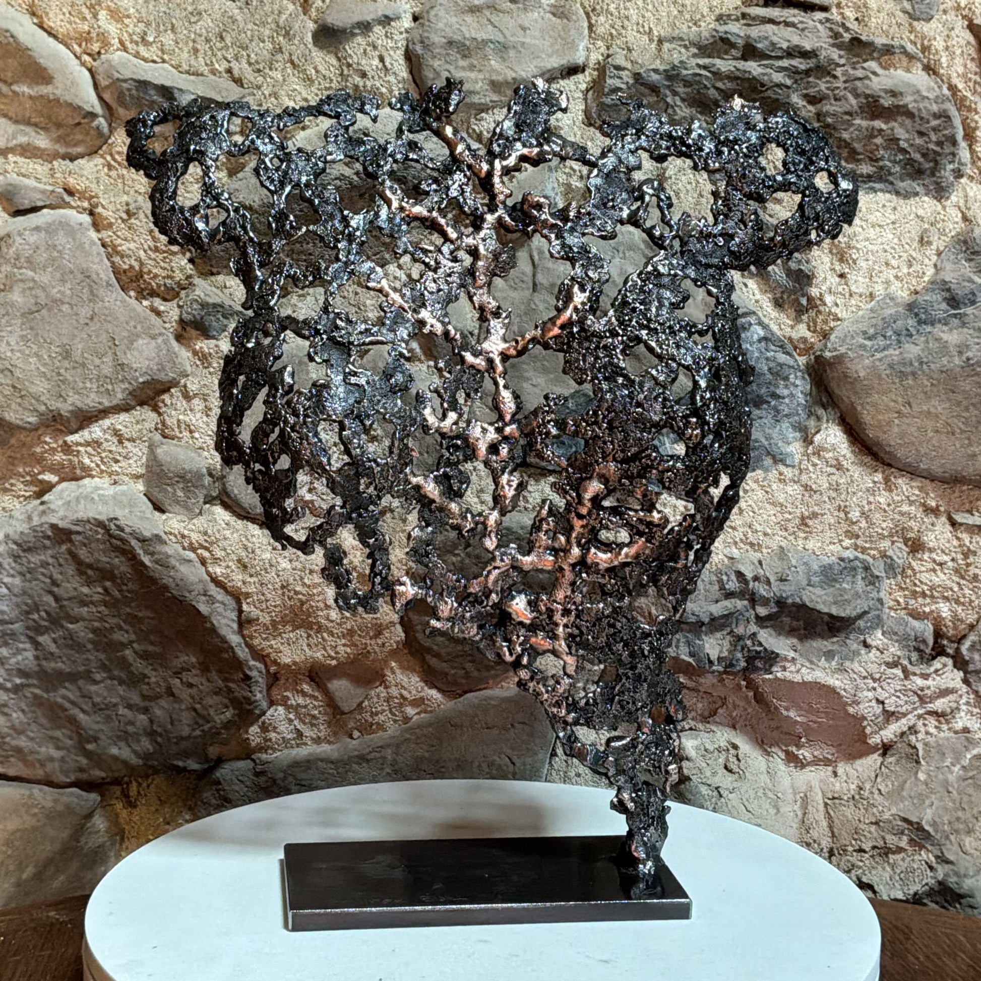 Belisama Au cœur de la matière intégrée dans un intérieur contemporain, sculpture d'art en acier et bronze.