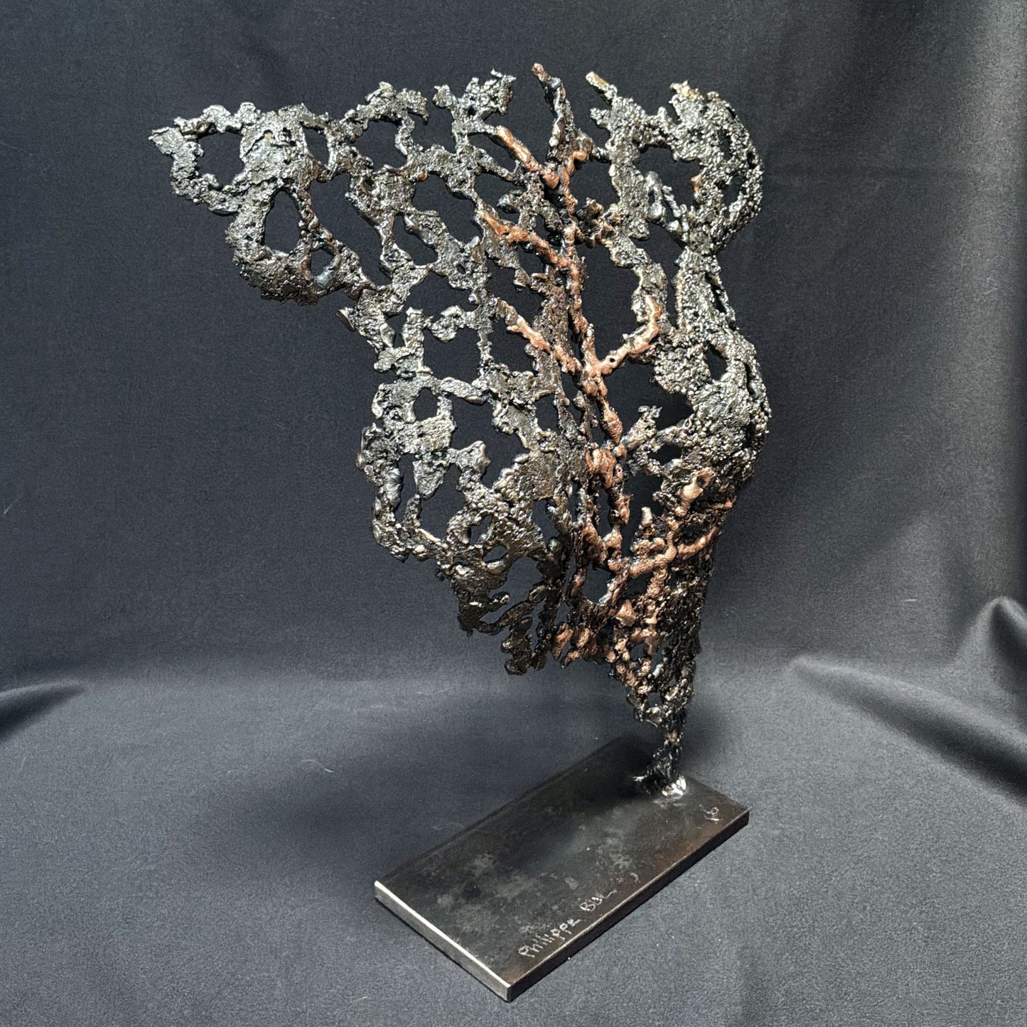 Vue trois quarts de Belisama Au cœur de la matière, sculpture contemporaine en acier et bronze ajouré.