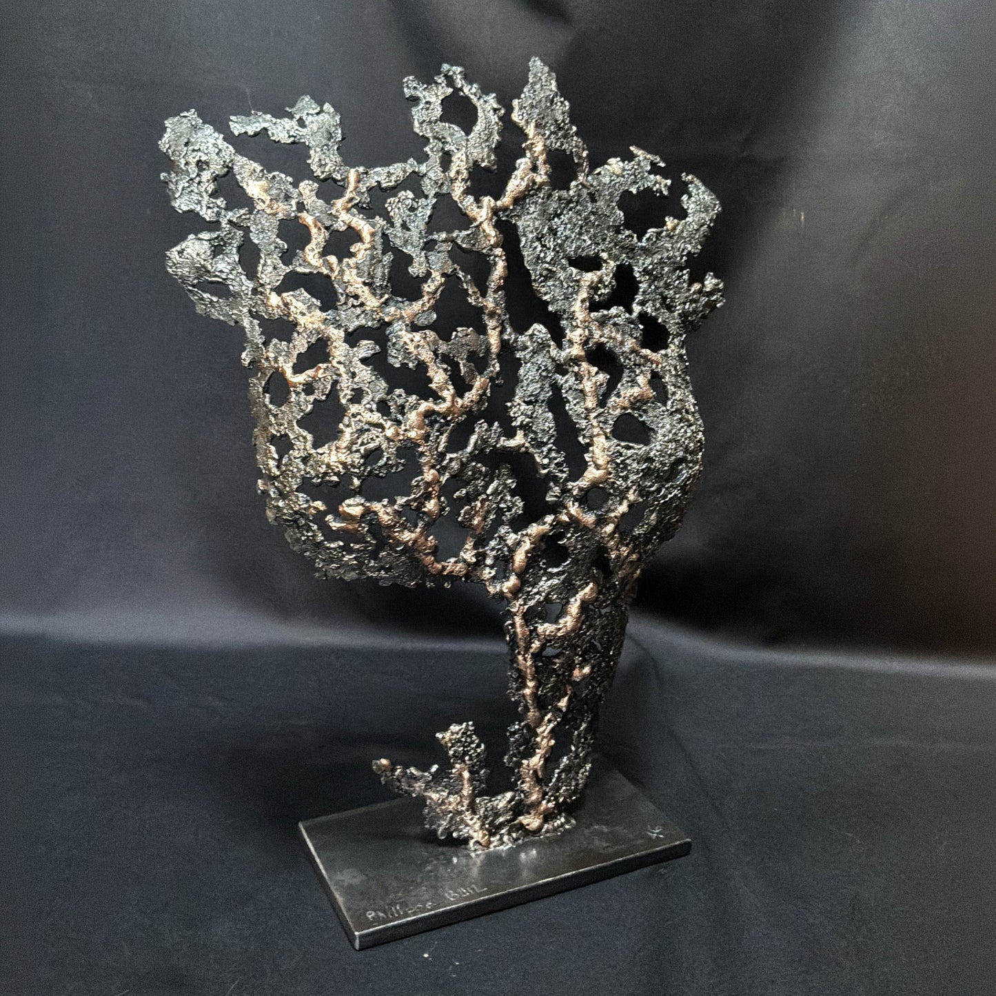 Au cœur du feu, sculpture contemporaine de corps féminin en acier et bronze présentée sur son socle