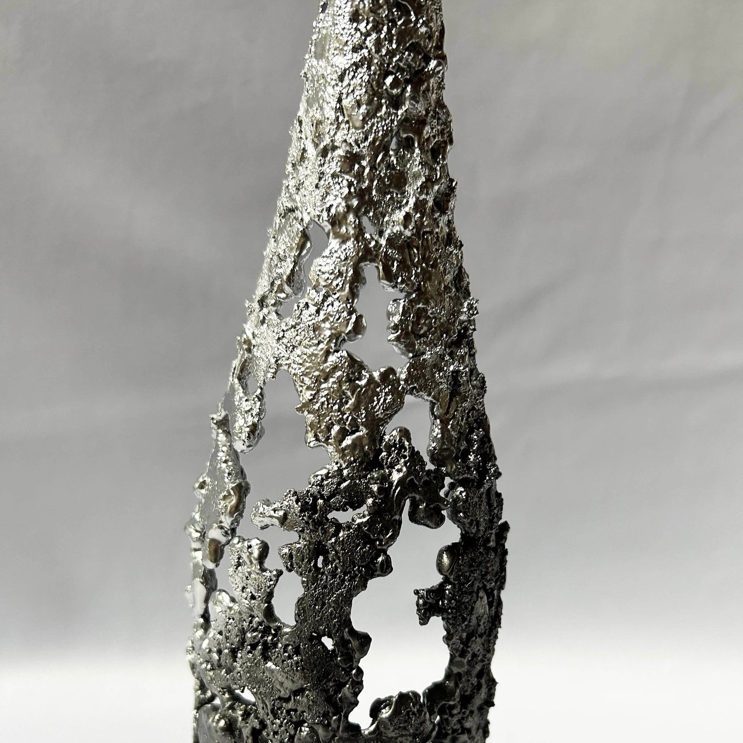 détail texture sculpture métal ajouré chrome