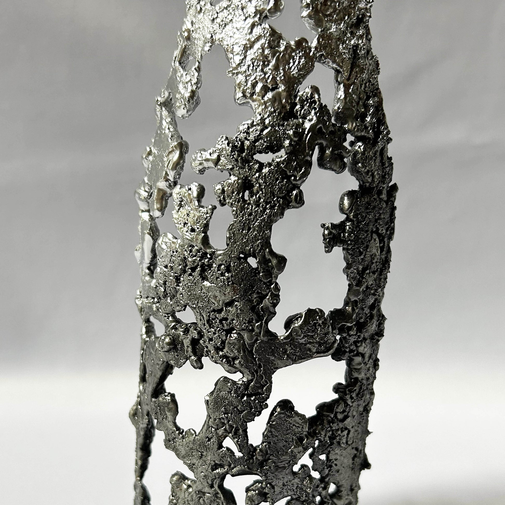 détail texture sculpture métal ajouré chrome