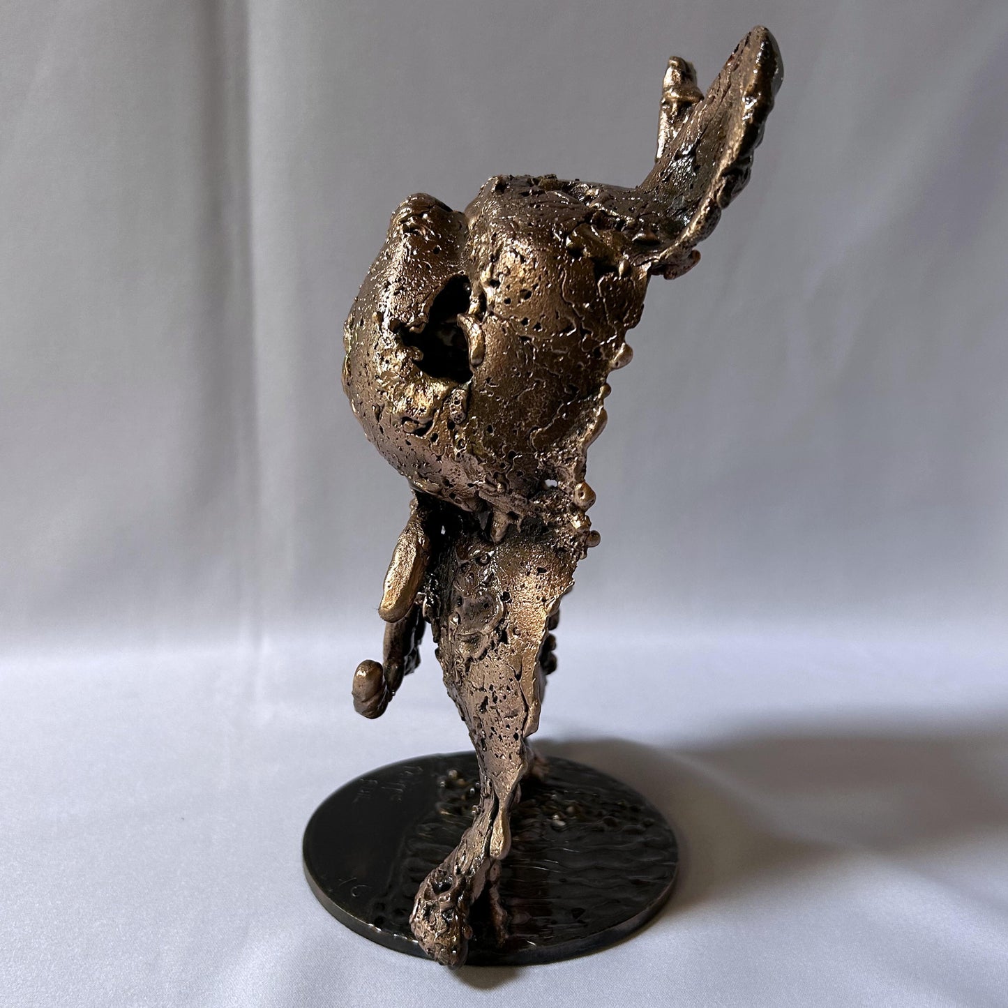 Sculpture de Philippe Buil représentant la face avant d'un chien fusionnée avec le célèbre logo Coco Chanel, réalisée en dentelle de métal acier et bronze