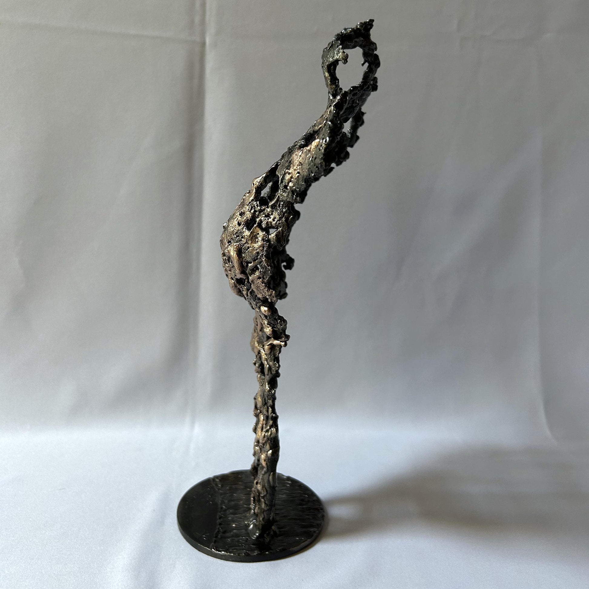 Cette sculpture de Philippe Buil représente un buste féminin, sublimé par une dentelle métallique ajourée, alliance de bronze et d'acier.