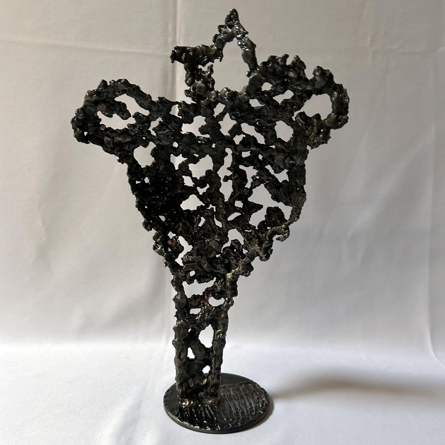 Cette sculpture de Philippe Buil représente un buste féminin, sublimé par une dentelle métallique ajourée, alliance de bronze et d'acier.