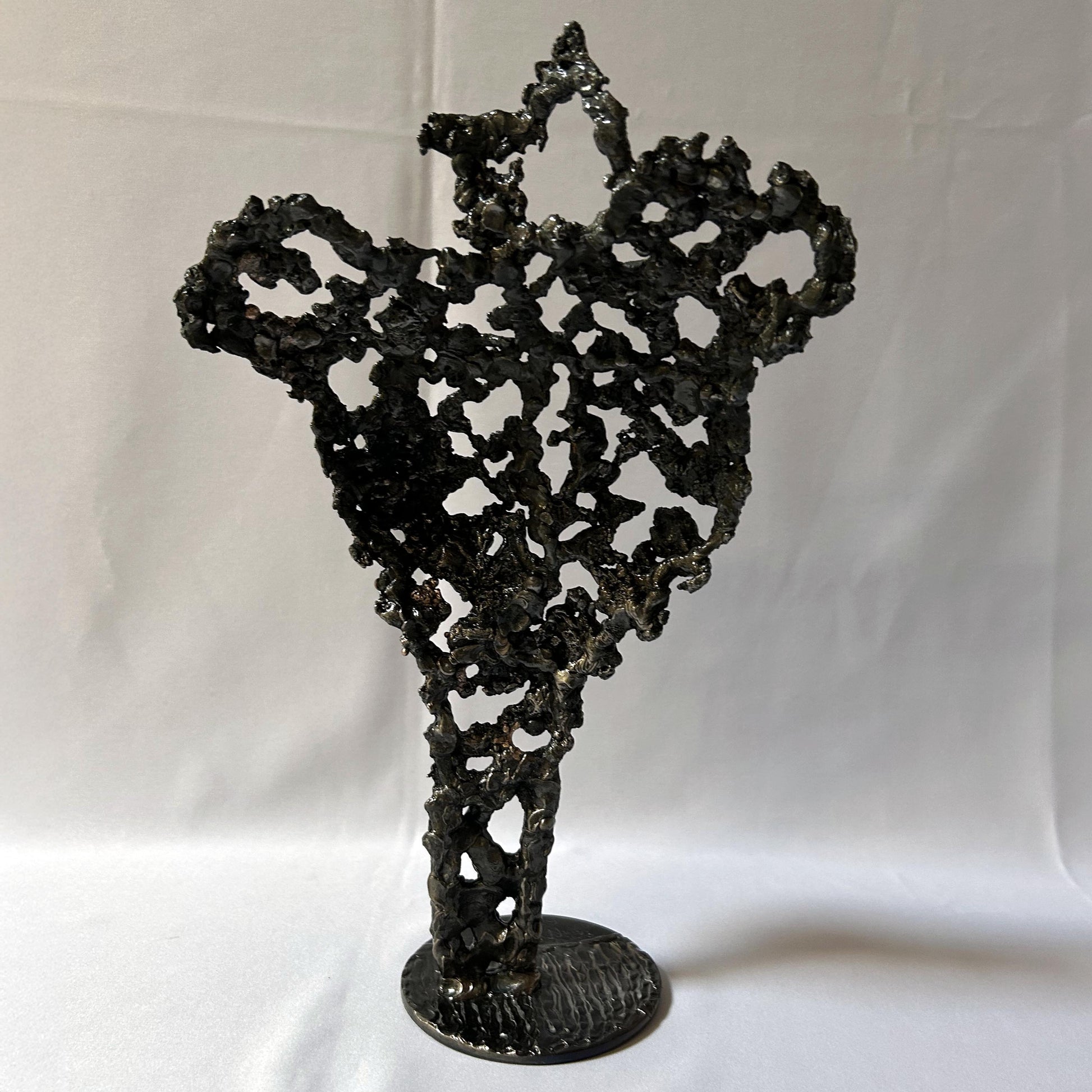 Cette sculpture de Philippe Buil représente un buste féminin, sublimé par une dentelle métallique ajourée, alliance de bronze et d'acier.