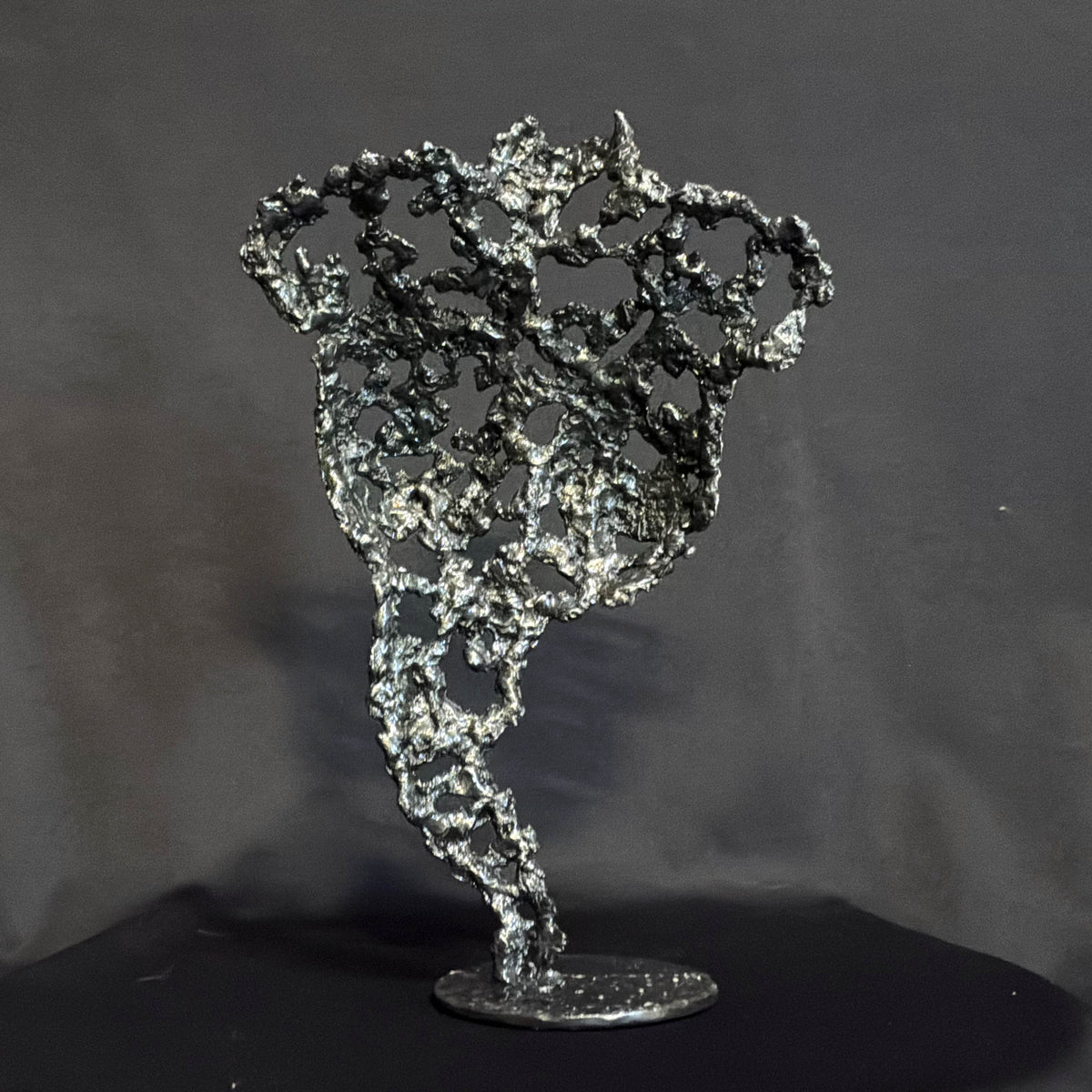 Vue arrière de Les Traces du Temps, sculpture féminine en dentelle de métal révélant la continuité de sa structure ajourée.