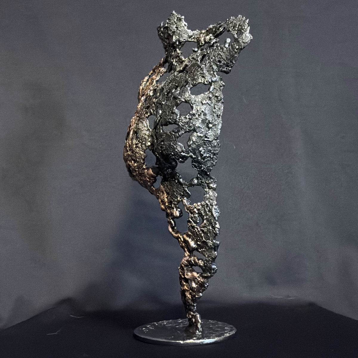 Profil droit de Les Traces du Temps, buste féminin en dentelle de métal aux reflets bronze et à la silhouette sculpturale.