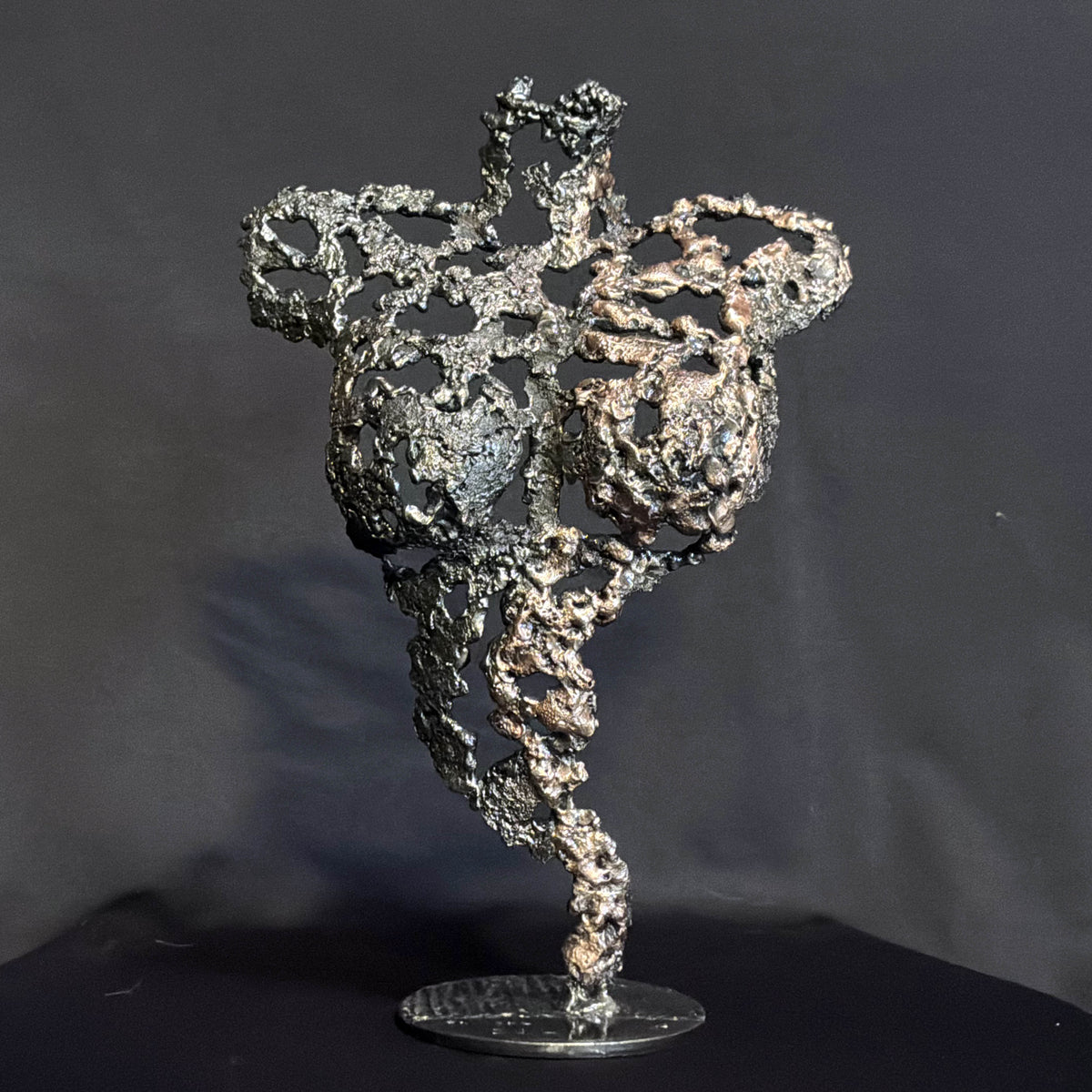 Les Signes de Demain, sculpture féminine en dentelle de métal vue de face, aux nuances sombres et bronze.