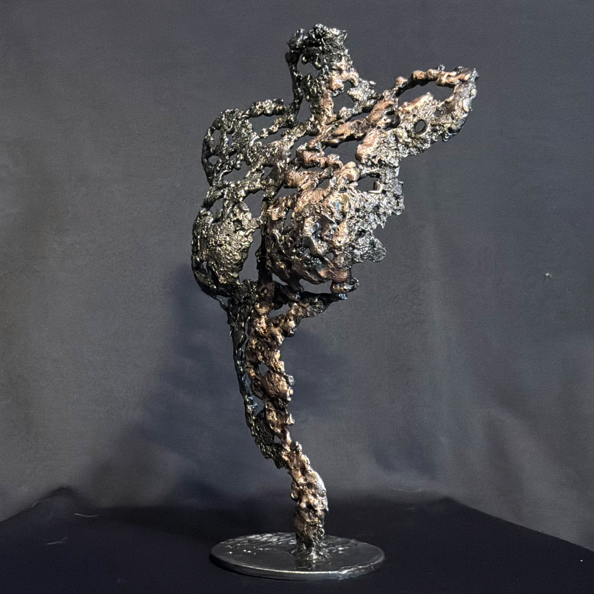 Vue de côté de Les Signes de Demain, sculpture féminine en dentelle de métal révélant la continuité de sa structure ajourée.