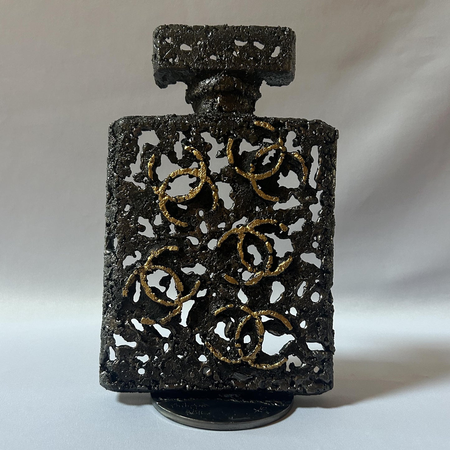 Sculpture de Philippe Buil représentant l'iconique flacon de parfum Chanel n°5 en dentelle de métal et dorure or.