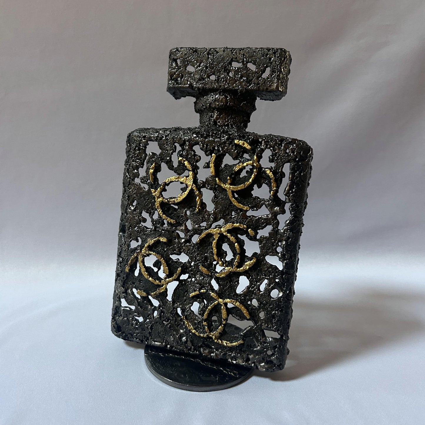 Sculpture de Philippe Buil représentant l'iconique flacon de parfum Chanel n°5 en dentelle de métal et dorure or.