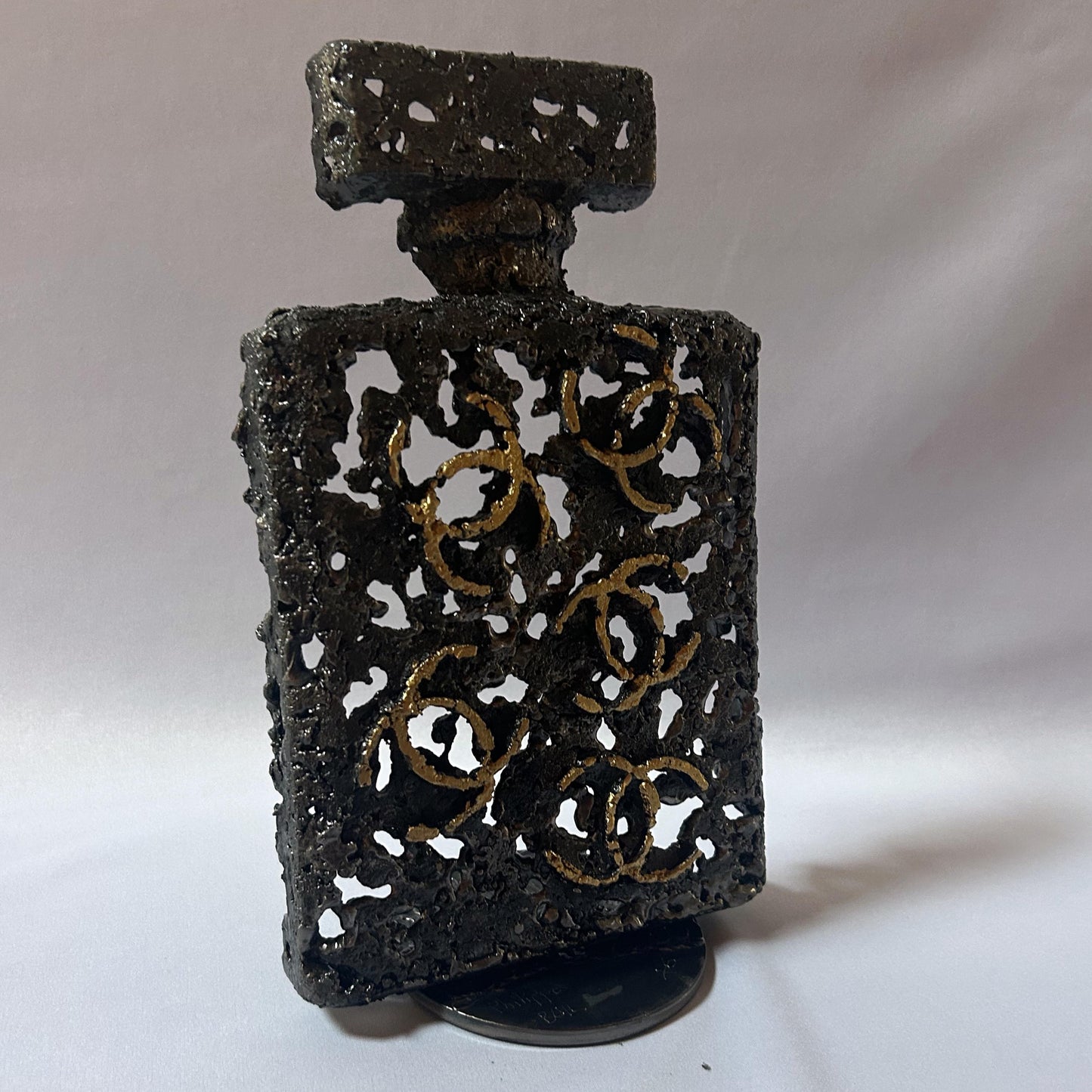 Sculpture de Philippe Buil représentant l'iconique flacon de parfum Chanel n°5 en dentelle de métal et dorure or.
