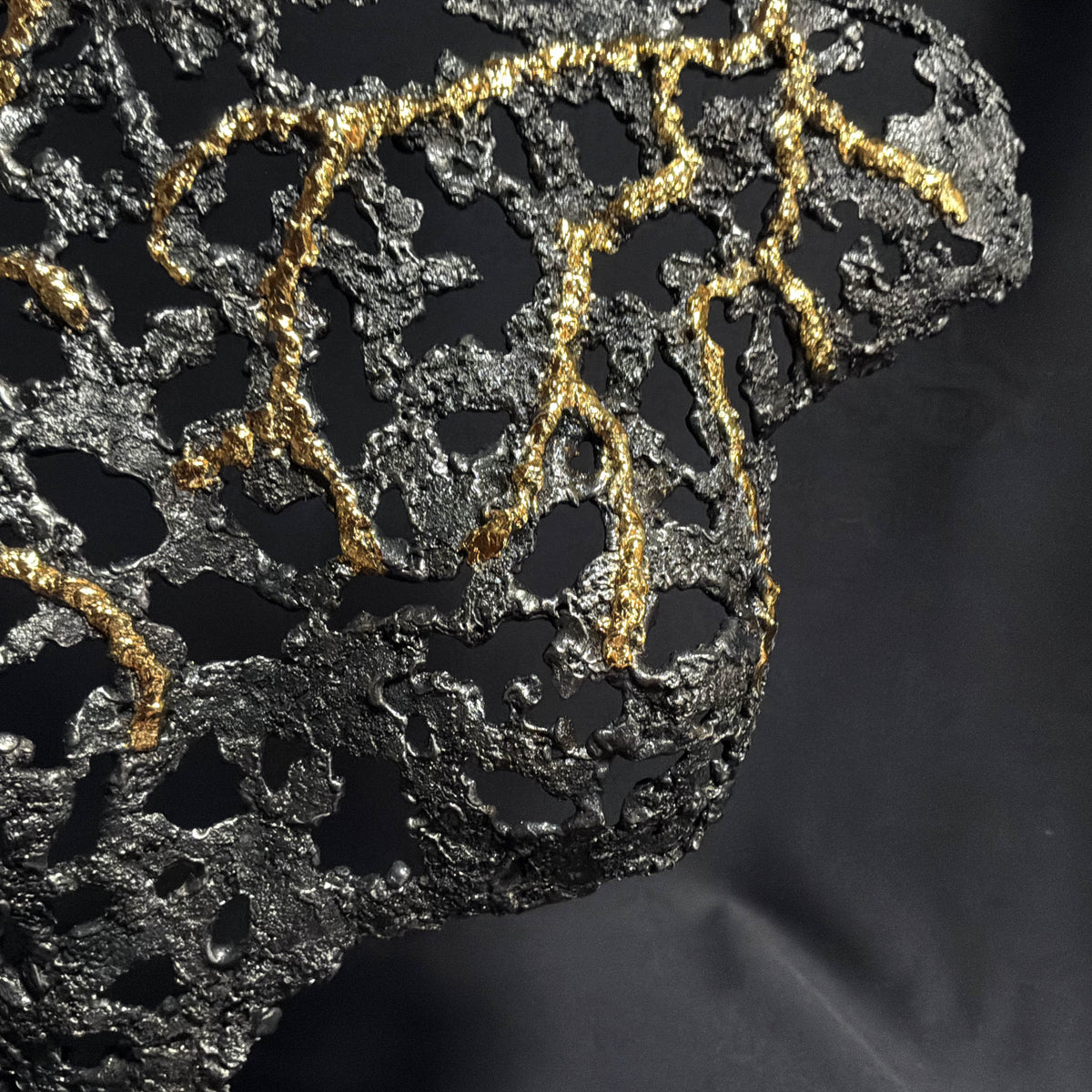 Détail de la structure métallique sombre et de la finition dorée de Belisama L’Alchimie intérieure