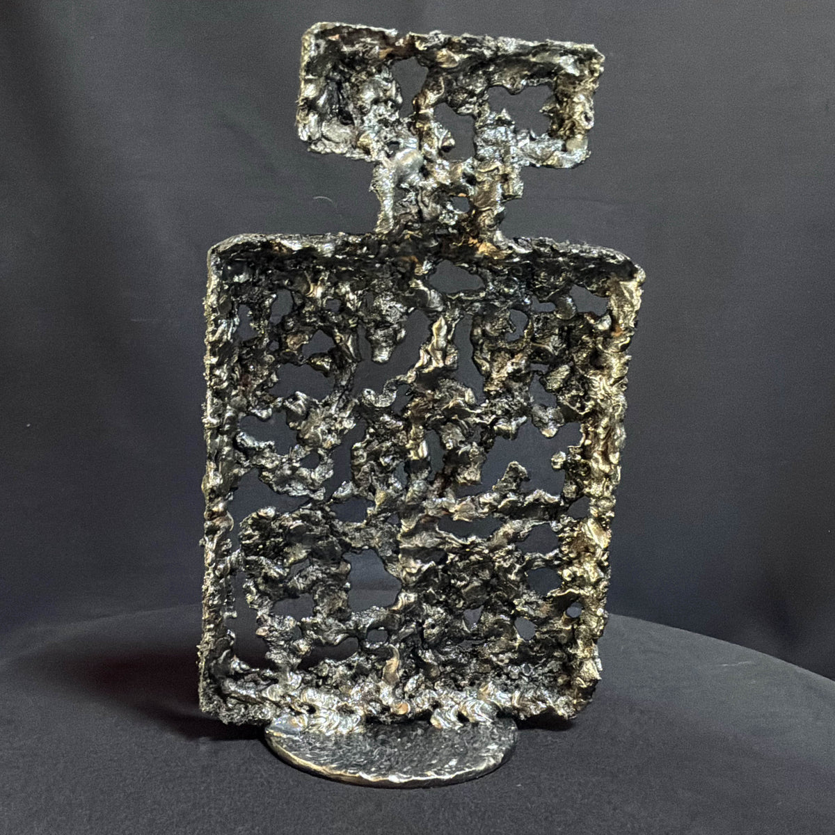 Dos de la sculpture Chanel N°5 en métal ajouré révélant le travail de la dentelle d’acier