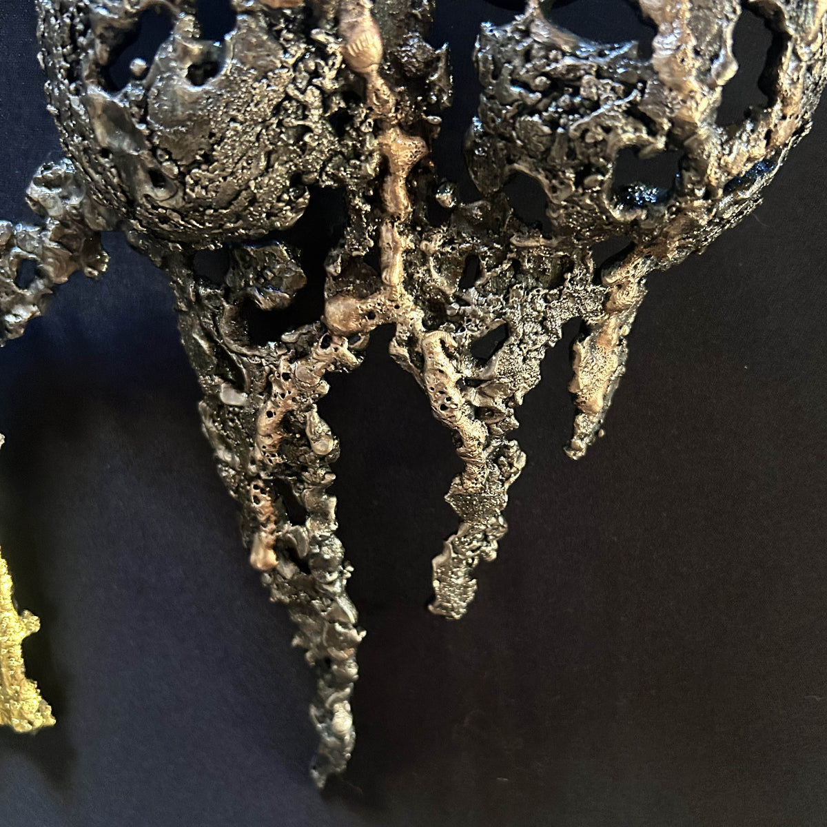 Détail de la dentelle d'acier et de bronze sur le buste féminin de La Splendeur du Temps, sur fond noir