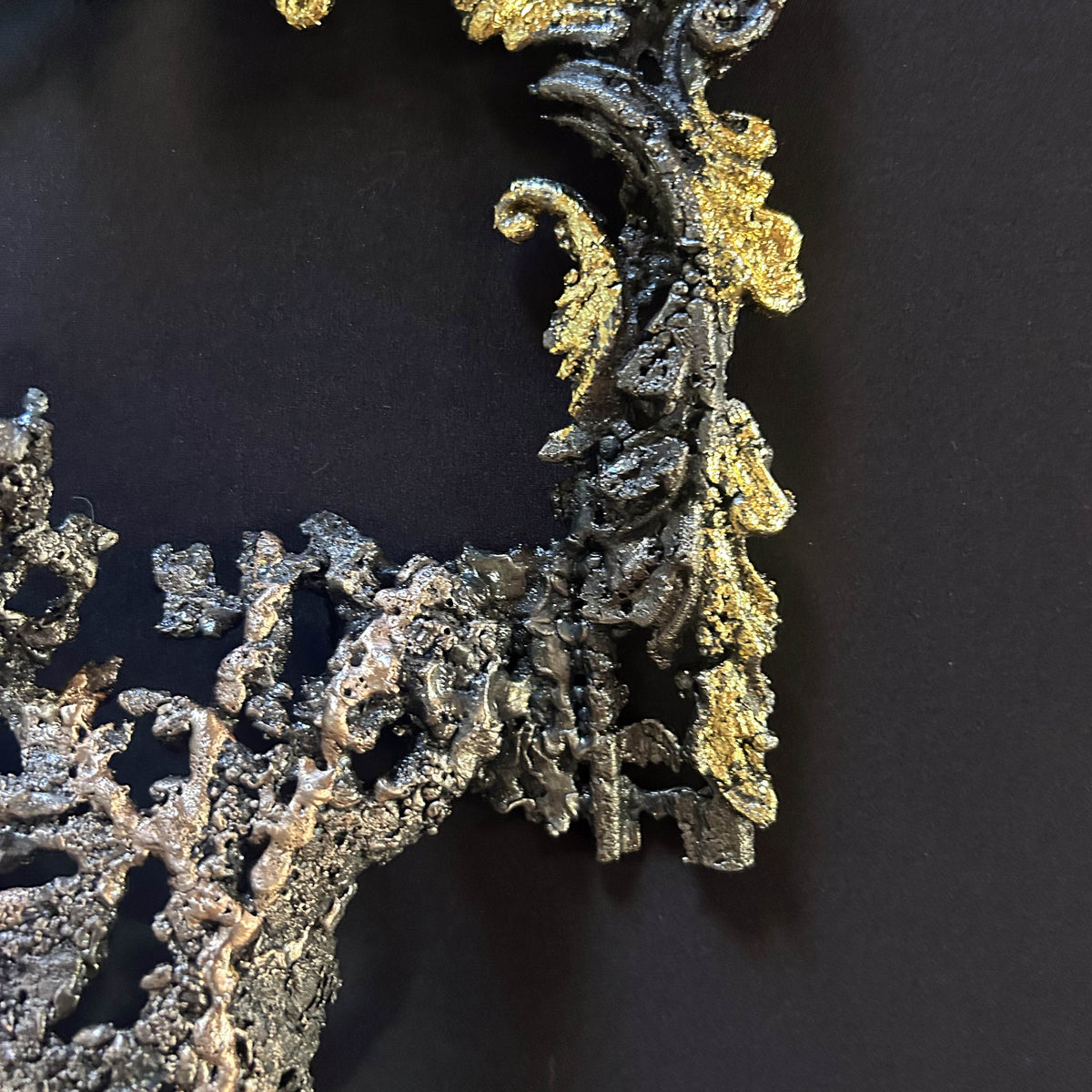 Feuilles métallisées dorées soulignant les arabesques du cadre sculpté