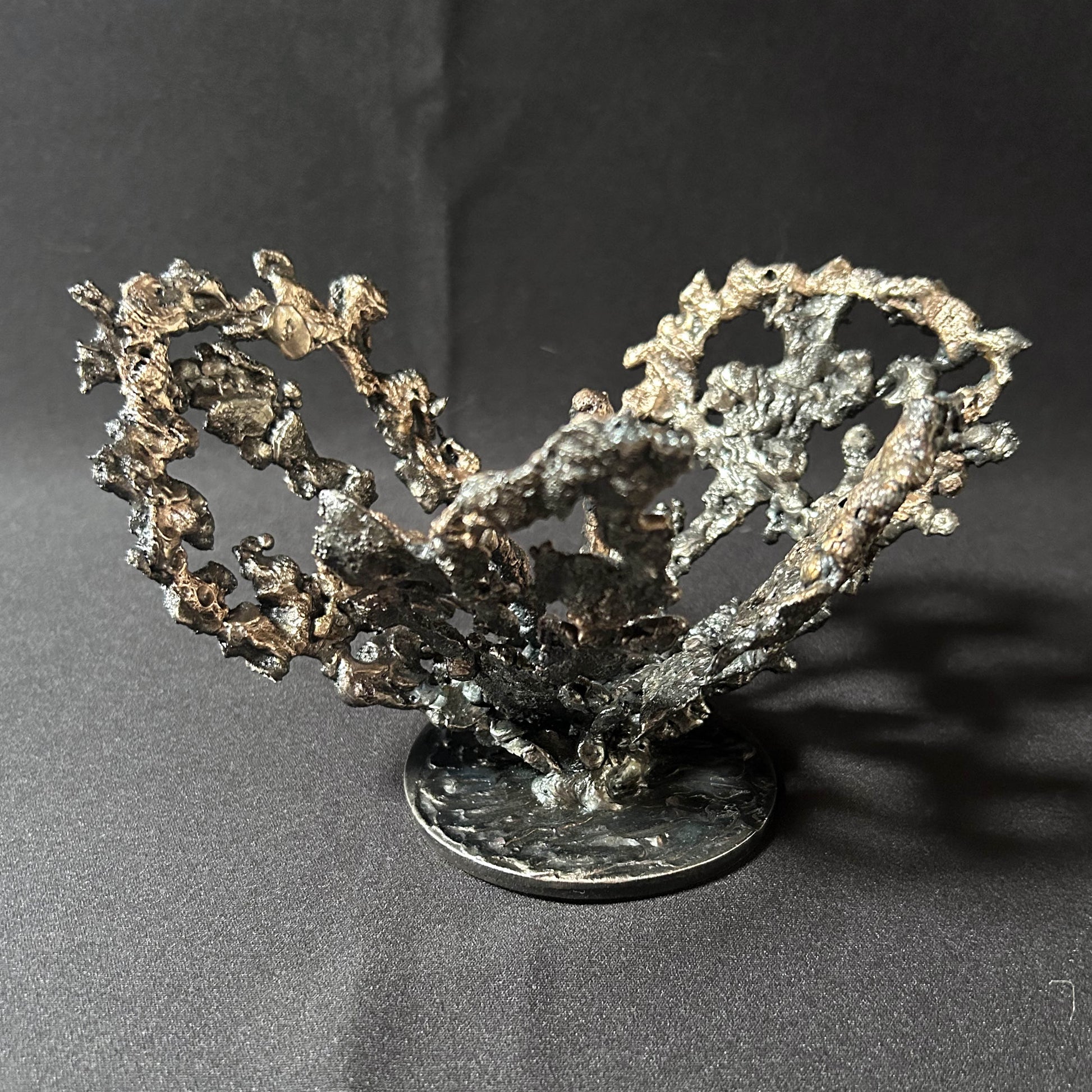 Cette œuvre unique de Philippe Buil, réalisée en dentelle de métal, capture la délicatesse et la force d’une fleur épanouie.