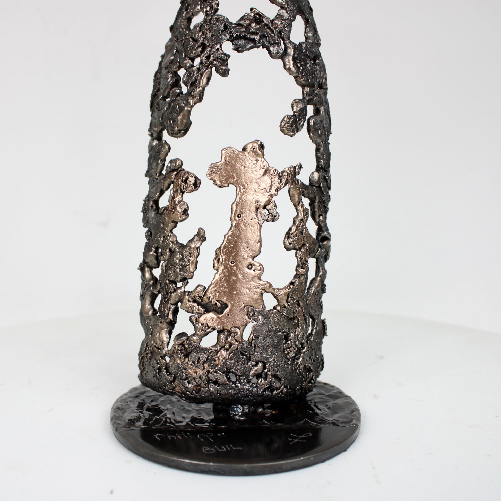 Sculpture de Philippe Buil représentant une bouteille de champagne en dentelle de métal : acier et bronze