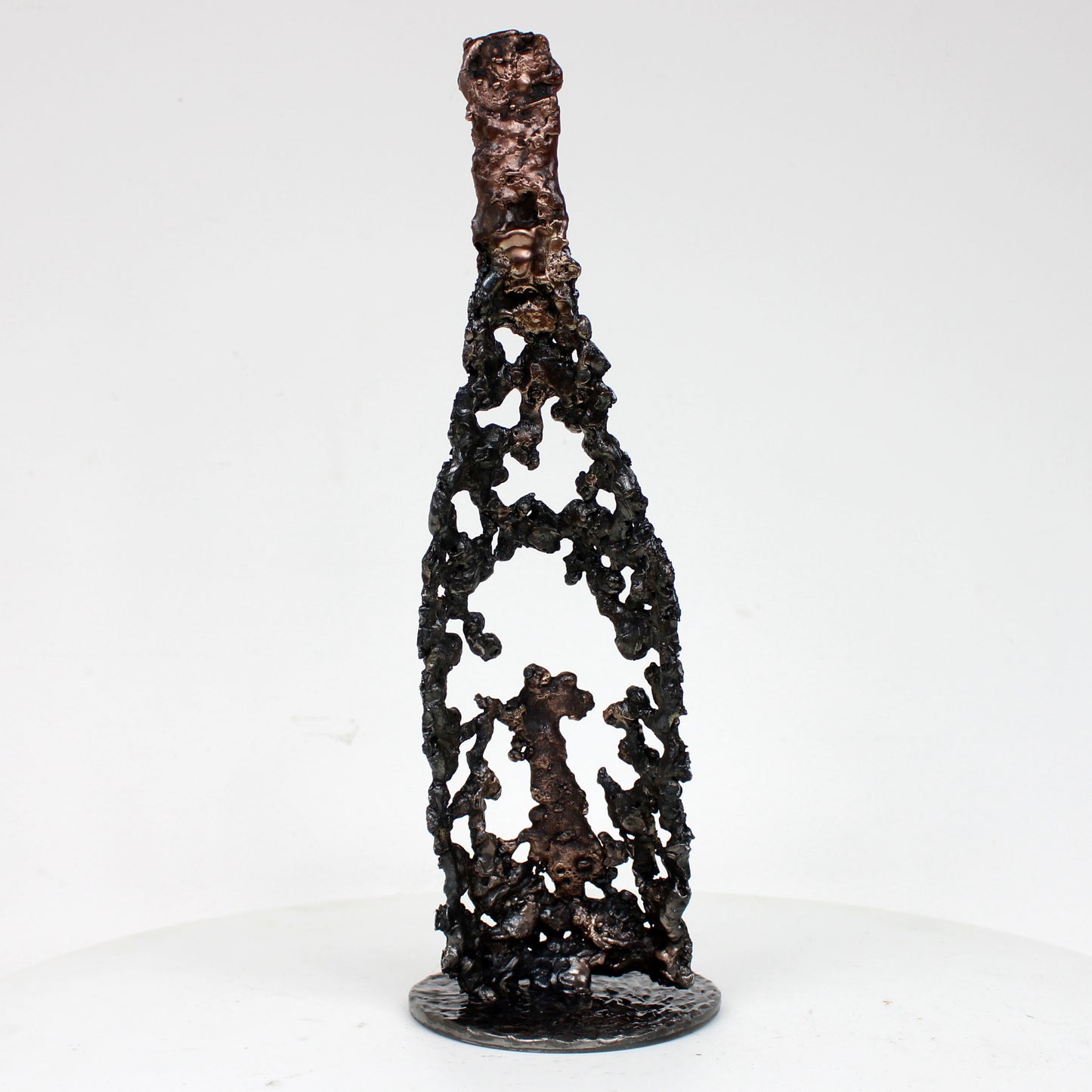 Sculpture de Philippe Buil représentant une bouteille de champagne en dentelle de métal : acier et bronze