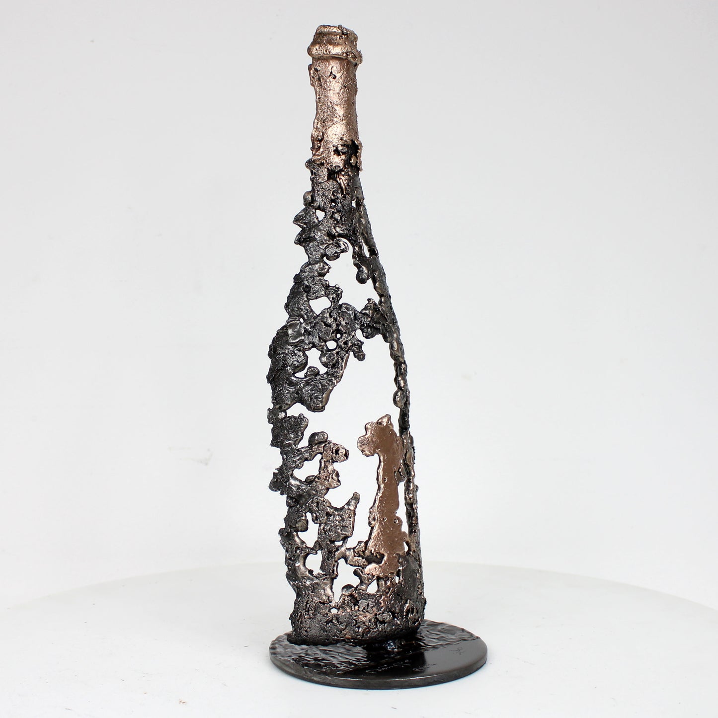 Sculpture de Philippe Buil représentant une bouteille de champagne en dentelle de métal : acier et bronze