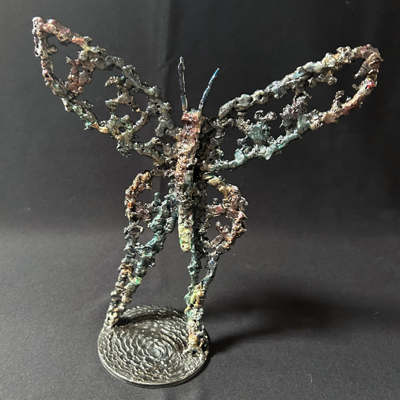 Sculpture de Philippe Buil représentant un papillon en dentelle de métal, symbole de légèreté et de transformation.