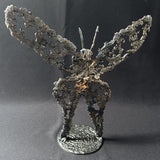 Sculpture de Philippe Buil représentant un papillon en dentelle de métal, symbole de légèreté et de transformation.