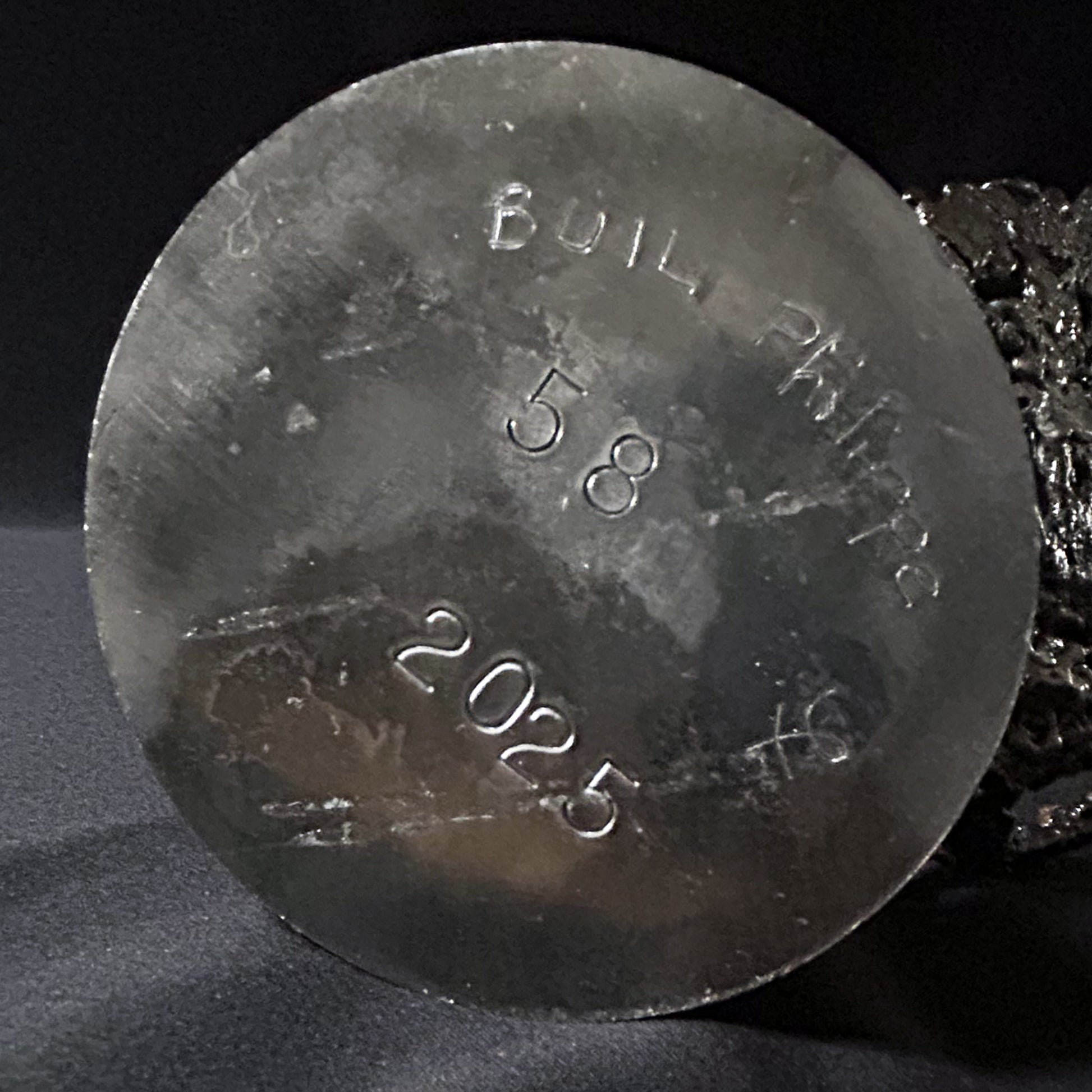 Sculpture abstraite de Philippe Buil : dentelle de métal en acier et bronze, reflets irisées et formes ajourées, œuvre unique contemporaine.