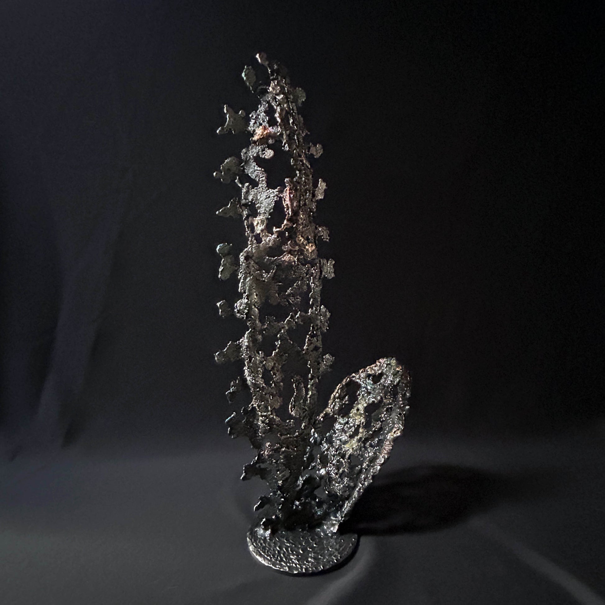 Sculpture abstraite de Philippe Buil : dentelle de métal en acier et bronze, reflets irisées et formes ajourées, œuvre unique contemporaine.