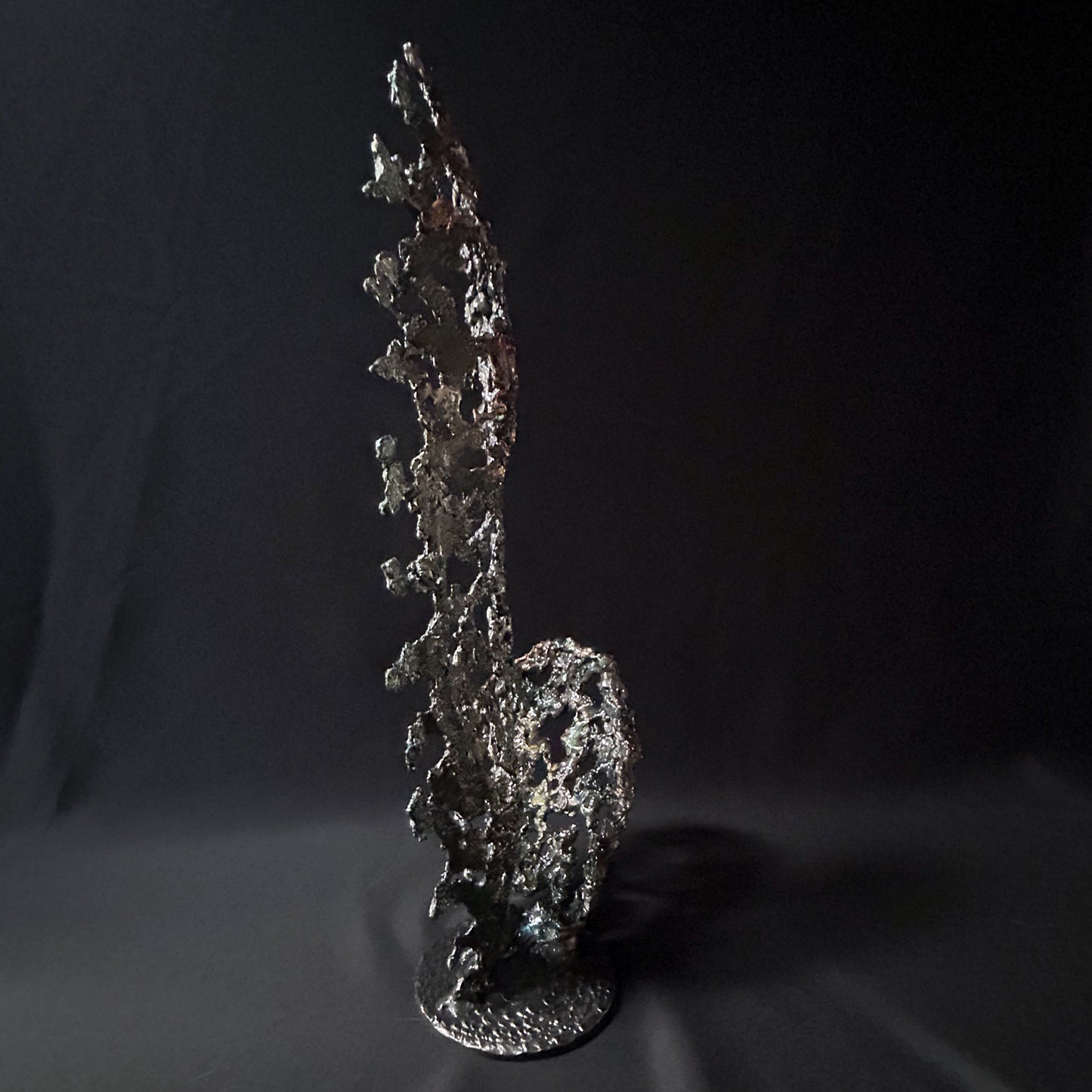 Sculpture abstraite de Philippe Buil : dentelle de métal en acier et bronze, reflets irisées et formes ajourées, œuvre unique contemporaine.